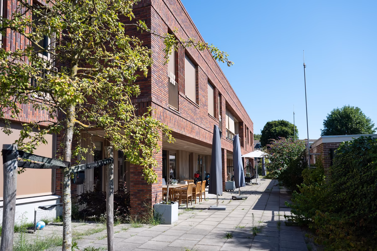 Buitenruimte van Duinrand 24 en 26 Woongebouw met terras en groene buitenruimte bij Duinrand 24 en 26