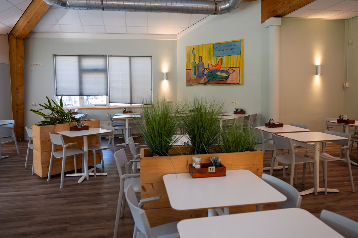 Restaurant De Waterjuffers Restaurantgedeelte met tafels, stoelen en groene planten