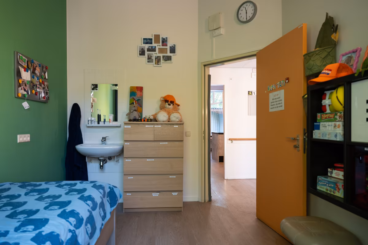 Slaapkamer bij Duinrand 25 Slaapkamer met bed, wastafel en persoonlijke opbergruimte bij Duinrand 25