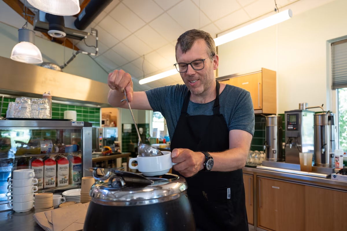 Soep uitserveren bij De Waterjuffers Cliënt schenkt soep in een kop in de keuken van De Waterjuffers