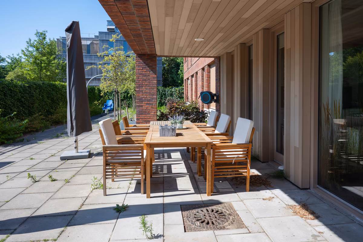 Terras van Duinrand 24 en 26 Beschut terras met grote tuintafel bij Duinrand 24 en 26